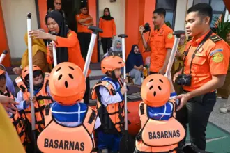 Personel Basarnas Palu mengarahkan anak-anak TK saat mencoba boat rescue di Kantor Basarnas Palu, Sulawesi Tengah, Senin (26/1/2026). (©bmzIMAGES/Basri Marzuki)