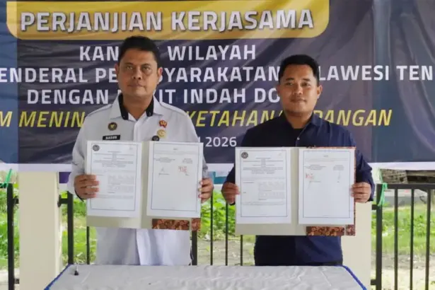 Kakanwil Ditjenpas Sulteng Bagus Kurniawan (kiri) dan Asisten Manajer Bukit Indah Doda Hotel & Resort Rizal menuynjukkan naskah PKS usai diteken di kebun asimiliasi Lapas Palu, Rabu (14/1/2026). (©Humas Ditjenpas Sulteng)