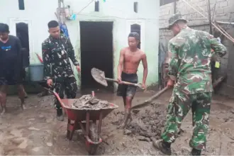 Sejumlah prajurit TNI AD membantu warga membersihkan rumahnya usai diterjang banjir di Tawaeli, Palu, Minggu (11/1/2026). (©Pendam23)