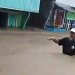 Warga menerobos banjir di Desa Wani, DOnggala, Minggu (11/1/2026). (©Tangkapan layar warga)