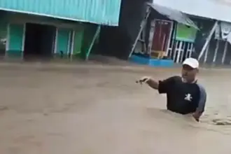 Warga menerobos banjir di Desa Wani, DOnggala, Minggu (11/1/2026). (©Tangkapan layar warga)