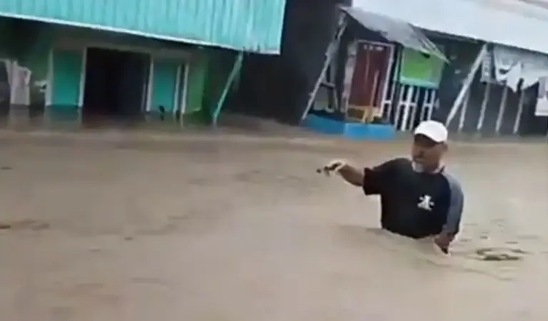 Warga menerobos banjir di Desa Wani, DOnggala, Minggu (11/1/2026). (©Tangkapan layar warga)