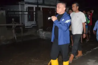 Wali Kota Palu Hadianto Rasyid saat meninjau banjir di Tawaeli, Minggu (11/1/2026) malam. (©Prokopim Setda Kota Palu)
