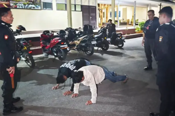 Dua pemuda pembawa parang melakukan push-up setelah diamankan Polisi Perintis Polda Sulteng di Palu, Minggu (25/1/2026). (©Humas Polda Sulteng)