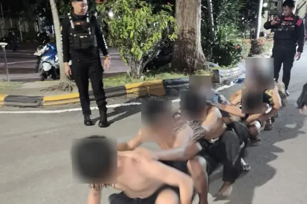 Petugas menggiring tujuh remaja yang diduga terlibat pelemparan rumah di Mapolresta Palu, Minggu (11/1/2026). (©Humas Polresta Palu)