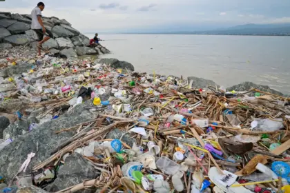 Warga memancing di dekat tumpukan sampah di pesisir Teluk Palu, Palu, Sulawesi Tengah, Selasa (20/1/2026). (©bmzIMAGES/Basri Marzuki)