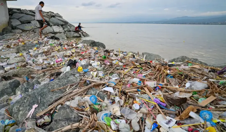 Warga memancing di dekat tumpukan sampah di pesisir Teluk Palu, Palu, Sulawesi Tengah, Selasa (20/1/2026). (©bmzIMAGES/Basri Marzuki)