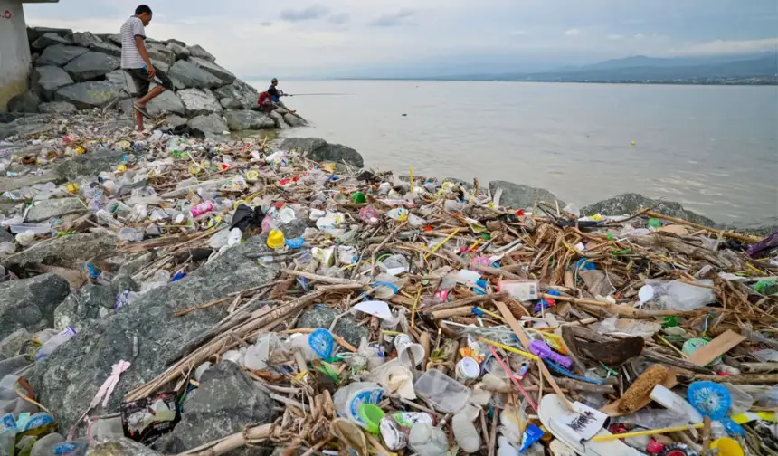 Warga memancing di dekat tumpukan sampah di pesisir Teluk Palu, Palu, Sulawesi Tengah, Selasa (20/1/2026). (©bmzIMAGES/Basri Marzuki)