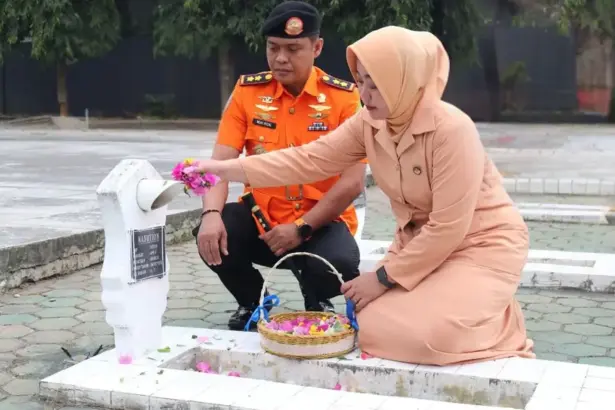 Kepala Badan Pencarian dan Pertolongan Palu. Moh Rizal bersama isteri menaburkan bunga pad amakam saat ziarah dalam rangka HUT ke-54 Basarnas, Jumat (27/2/2026). (©Basarnas Palu)