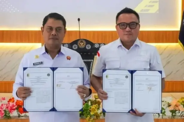 Bupati Morut Denis J Hehi (kanan) bersama Kakanwil Ditjenpas Sulteng Bagus Kurniawan menunjukkan naskah PKS penguatan layanan pemasyarakatan di Morut, Jumat (13/2/2026). (©Hum,as Ditjenpas Sulteng)