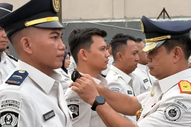 Kakanwil Ditjenpas Sulteng Bagus Kurniawana (kanan) menyematkan tanda kenaikan pangkat kepada pegwai di lingkungan Kanwil Ditjenpas Sulteng, Senin (9/2/2026). (©HUmas Kanwil Ditjenpas Suletng)