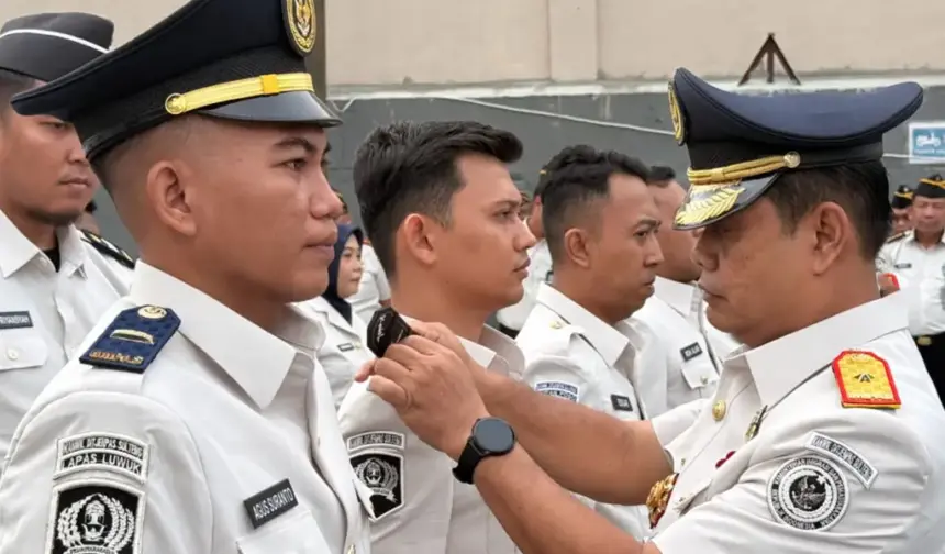 Kakanwil Ditjenpas Sulteng Bagus Kurniawana (kanan) menyematkan tanda kenaikan pangkat kepada pegwai di lingkungan Kanwil Ditjenpas Sulteng, Senin (9/2/2026). (©HUmas Kanwil Ditjenpas Suletng)