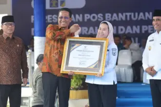 Wakil Wali KOta Palu Imelda Liliana Muhidin menerima penghargaan dari Menkum Supratman Andi Agtas disaksikan menteri PDT Yandri Susanto dan Gubernur Sulteng Anwar Hafid pada persemian Posbankum se Sulteng di Lapangan Pogombo, Rabu 94/2/2026). (©bmzIMAGES/Basri Marzuki)