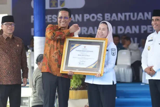 Wakil Wali KOta Palu Imelda Liliana Muhidin menerima penghargaan dari Menkum Supratman Andi Agtas disaksikan menteri PDT Yandri Susanto dan Gubernur Sulteng Anwar Hafid pada persemian Posbankum se Sulteng di Lapangan Pogombo, Rabu 94/2/2026). (©bmzIMAGES/Basri Marzuki)
