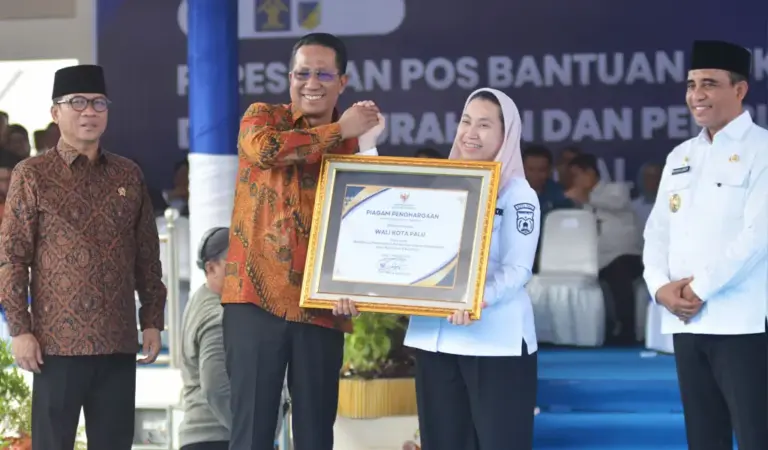 Wakil Wali KOta Palu Imelda Liliana Muhidin menerima penghargaan dari Menkum Supratman Andi Agtas disaksikan menteri PDT Yandri Susanto dan Gubernur Sulteng Anwar Hafid pada persemian Posbankum se Sulteng di Lapangan Pogombo, Rabu 94/2/2026). (©bmzIMAGES/Basri Marzuki)
