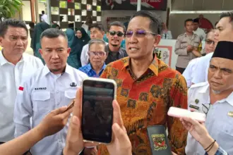 Menkum Supratman Andi Agtas didampingi Plt Asisten Bidang Perekonomian dan Pembangunan Setda Kota Palu Rahmat Mustafa memberikan keterangan kepada wartawan usai meresmikaan Gerai Koperasi Merah Putih Kelurahan Talise di Palu, Rabu 94/2/2026). (©Prokopim Setda Kota Palu/Jufri)