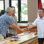 Plt. Asisten Bidang Perekonomian dan Pembangunan Setda Kota Palu, Rahmad Mustafa (kanan) menyalami delegasi Myanmar pada sharing pemulihan pascabencana di palu, Rabu (25/2/2026). (©Prokopim Setda Kota Palu/Jufri)