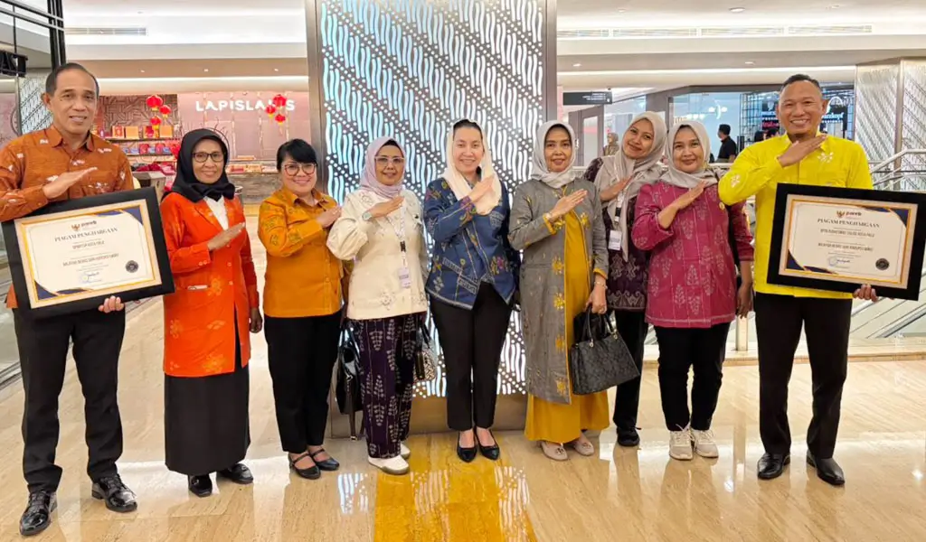 Waali Palu Imelda Liliana Muhidin (tengah) bersama Kepala DPmPTSP dan Kepala Puskesmas Talise menunjukkan sertifikat penghargaan yang baru diteriam dari Kemen PAN-RB di Jakarta, Rabu (11/2/2026). (©Diskominfosantik Palu)