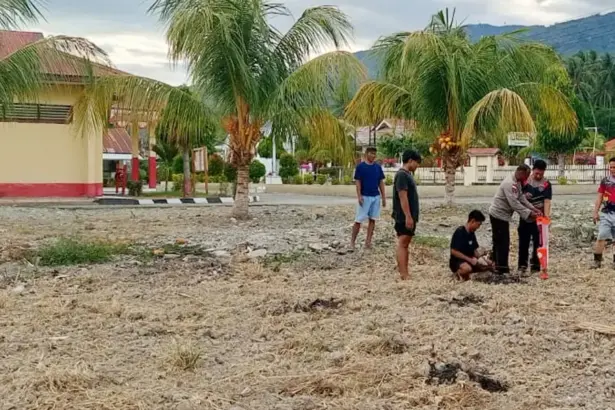 Sejumlah anggota polisi menanam jagung di lahan kosong markas Polsek Tomini, Parimo, Kamis (12/2/2026). (©Polres Parimo)