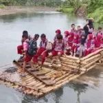 Anak-anak berangkat ke sekolah menyeberangi sungai dengan rakit di Desa Tonggolobibi, Sojol, Donggala. (©Risman Yunus)