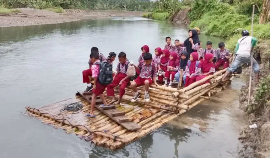Anak-anak berangkat ke sekolah menyeberangi sungai dengan rakit di Desa Tonggolobibi, Sojol, Donggala. (©Risman Yunus)