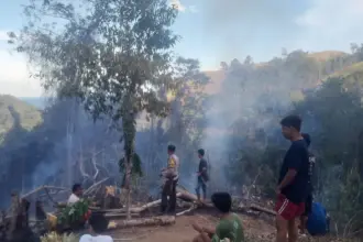 Polisi bersama warga berada di dekat pepohonan bekas terbakar di Desa Sakinah Jaya, Parigi Utara, Kamis (5/2/2026). (©Polres Parimo)