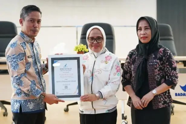 Kepala Balai POM Palu Mardianto (kiri) menyerahkan piagam penghargaan kepada Sekda Kota Palu Irmayanti sebagai Kota Aman Pangan di Palu, Kamis (19/2/2026). (©Prokopim Setda Kota Palu/Jufri)