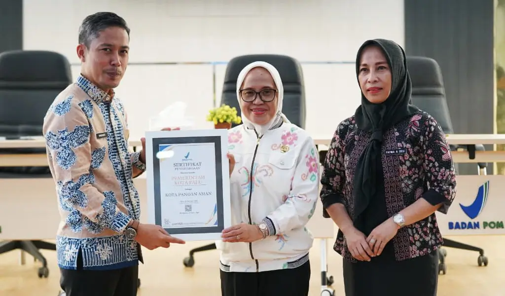 Kepala Balai POM Palu Mardianto (kiri) menyerahkan piagam penghargaan kepada Sekda Kota Palu Irmayanti sebagai Kota Aman Pangan di Palu, Kamis (19/2/2026). (©Prokopim Setda Kota Palu/Jufri)