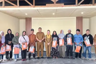 Foto bersama Wawali Kota Palu usai penyerahan APD kepada pekerja padat karya di Kantr Kelurahan Talise, Palu, Senin (23/2/2026). (©Prokpim Setda Kota Palu)