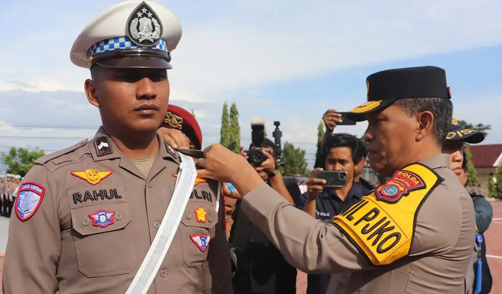 Wakapolda Brigjen Pol Dr Helmi Kwarta Kusuma Putra Rauf menyematkan pita kepada personel menandai dimualian Operasi Keselamatan Tinombala 2026 di Mapolda Sulteng, Senin (2/2/2026). (©Humas Polda Sulteng)