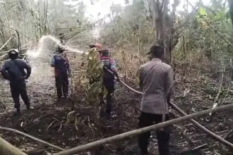 Aparat kepolisian bersama warga berusaha memadamkan api yang mebakar lahan warga di Desa Bamabalemo Parimo, Jumat (27/2/2026). (©HUmas Polres Parimo)