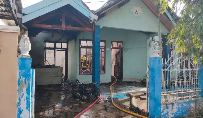 Petugas memadamkan api yang membakar rumah di BTN Bumi Anggur Palu, Minggu (15/2/2026). (©Humas Polresta Palu)