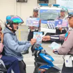 Kasatlantas Polresta Palu, AKP Atmaji Sugeng Wibowo membagikan brosur kepada pengendara pada Operasi Keselamatan Tinombala 2026 di Palu, Kamis (12/2/2026). (©Humas Polresta Palu)
