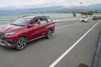 Pengendara melamabikan tangan saat uji coba melintas di Jembatan Palu IV, Senin (9/2/2026). (©bmzIMAGES/Basri Marzuki)