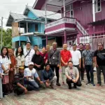 Para penyintas bencana yang menghuni Huntap Mandiri Mamboro berfoto dengan manajemen AirAsia di Hunta Mamboro, Sabtu (7/3/2026). (©Heri)