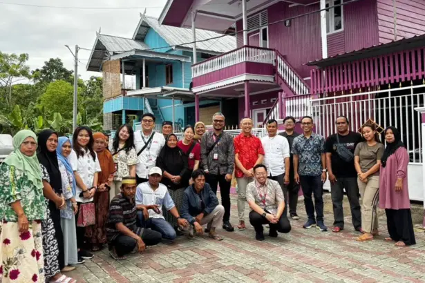 Para penyintas bencana yang menghuni Huntap Mandiri Mamboro berfoto dengan manajemen AirAsia di Hunta Mamboro, Sabtu (7/3/2026). (©Heri)