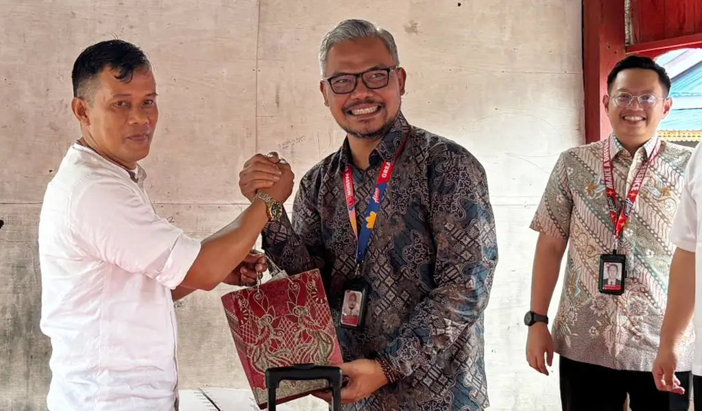 Ketua RT Huntap Mamboro menyerahkan cindera mata kepada Head of Indonesia Affairs and Policy Indonesia AirAsia, Eddy Krismeidi Soemawilaga di Huntap Mandiri Mamboro, Sabtu (7/3/2026). (©Heri)