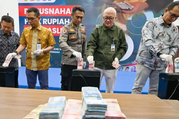 Kepala Perwakilan BI Sulteng Irfan Sukarna (kedua kanan) bersama sejumlah pejabat Sulteng memasukkan uang palsu ke mesin pencacah pada pemusnahan uang rupiah tidak asli di Ruang Kasiromu, BI Sulteng, Kamis (5/3/2026). (©bmzIMAGES/Basri Marzuki)