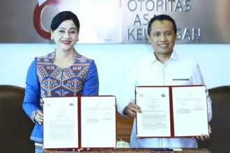 Pjs Wakil Ketua Dewan Komisioner OJK, Friderica Widyasari Dewi dan Kepala Bareskrim Polri, Komjen Pol Syahardiantono menunjukkan naskah PKS usai diteken di Jakarta, Selasa (3/3/2026). (©OJK)