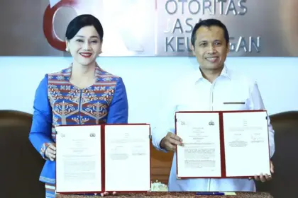 Pjs Wakil Ketua Dewan Komisioner OJK, Friderica Widyasari Dewi dan Kepala Bareskrim Polri, Komjen Pol Syahardiantono menunjukkan naskah PKS usai diteken di Jakarta, Selasa (3/3/2026). (©OJK)