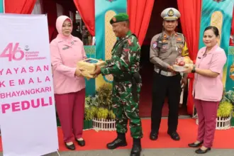 Ketua Bhayangkari Cabang Kota Palu, Dhinie Hari Rosena menyerahkan parsel kepada personel Pos Pengamanan Lebaarn di Palu, Selasa (17/3/2026). (©Humas Polresta Palu)
