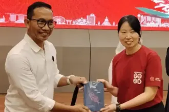 Direktur Arkom Indonesa Yuli Kusworo menyerahkan buku "pilah Pilih Pulih kepada manajemen AirAsia pada peluncurannya di Palu, Jumat (6/3/2026). (©Arkom Indonesia)