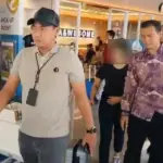 Petugas mengawal tersangka kasus dugaan tindak pidana perbankan. (©OJK)
