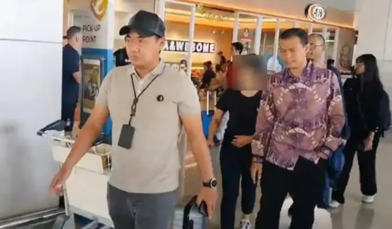 Petugas mengawal tersangka kasus dugaan tindak pidana perbankan. (©OJK)