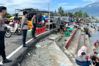 Petugas berjaga di Pantai Kampung Nelayan, Minggu (22/3/2026). (©Humas Polda Sulteng)