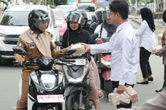 Personel Satresnarkoba Polresta Palu membagikan tajil buka puasa kepada pengendara di Palu, Senin (9/3/2026). (©Humas Polresta Palu)