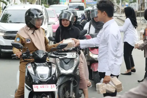 Personel Satresnarkoba Polresta Palu membagikan tajil buka puasa kepada pengendara di Palu, Senin (9/3/2026). (©Humas Polresta Palu)