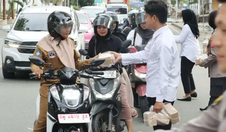 Personel Satresnarkoba Polresta Palu membagikan tajil buka puasa kepada pengendara di Palu, Senin (9/3/2026). (©Humas Polresta Palu)
