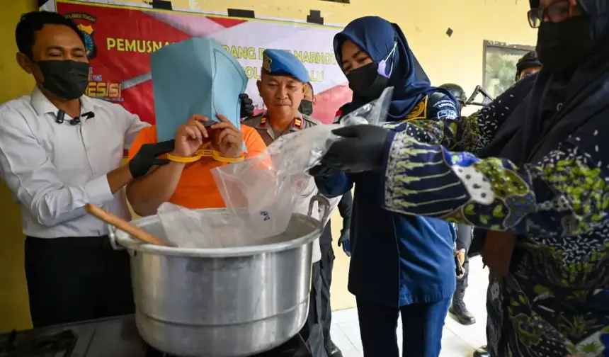 Kasat Reserse Narkoba Polresta Palu Kompol Usman (kiri) menyaksikan tersangka ARI menuang sabu ke dalam panci pada pemusnahan babuk di Mapolresta Palu, Kamis (12/3/2026). (©bmzIMAGES/Basri Marzuki)