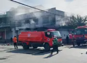 Petugas berusaha memadamkan api yang membakar ruko di Jalan Danau Lindu Palu, Selasa (7/4/2026). (©Humas Polresta Palu)
